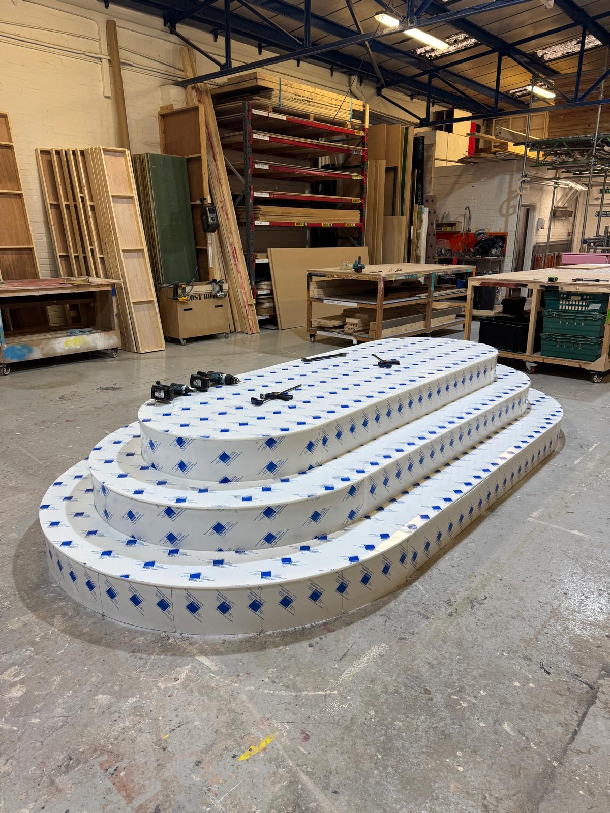 Bespoke acrylic stage with protective film in a set builders warehouse