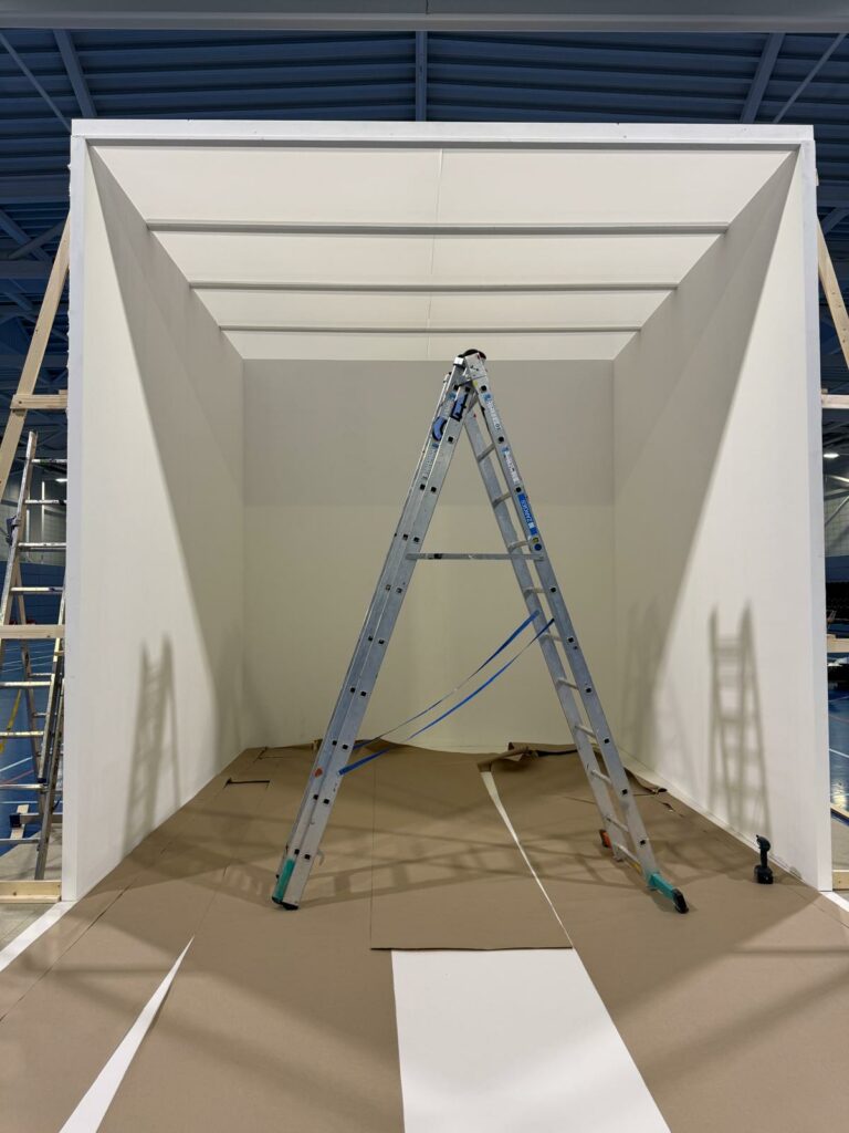 Set builders using our materials to construct a very large open sided white box