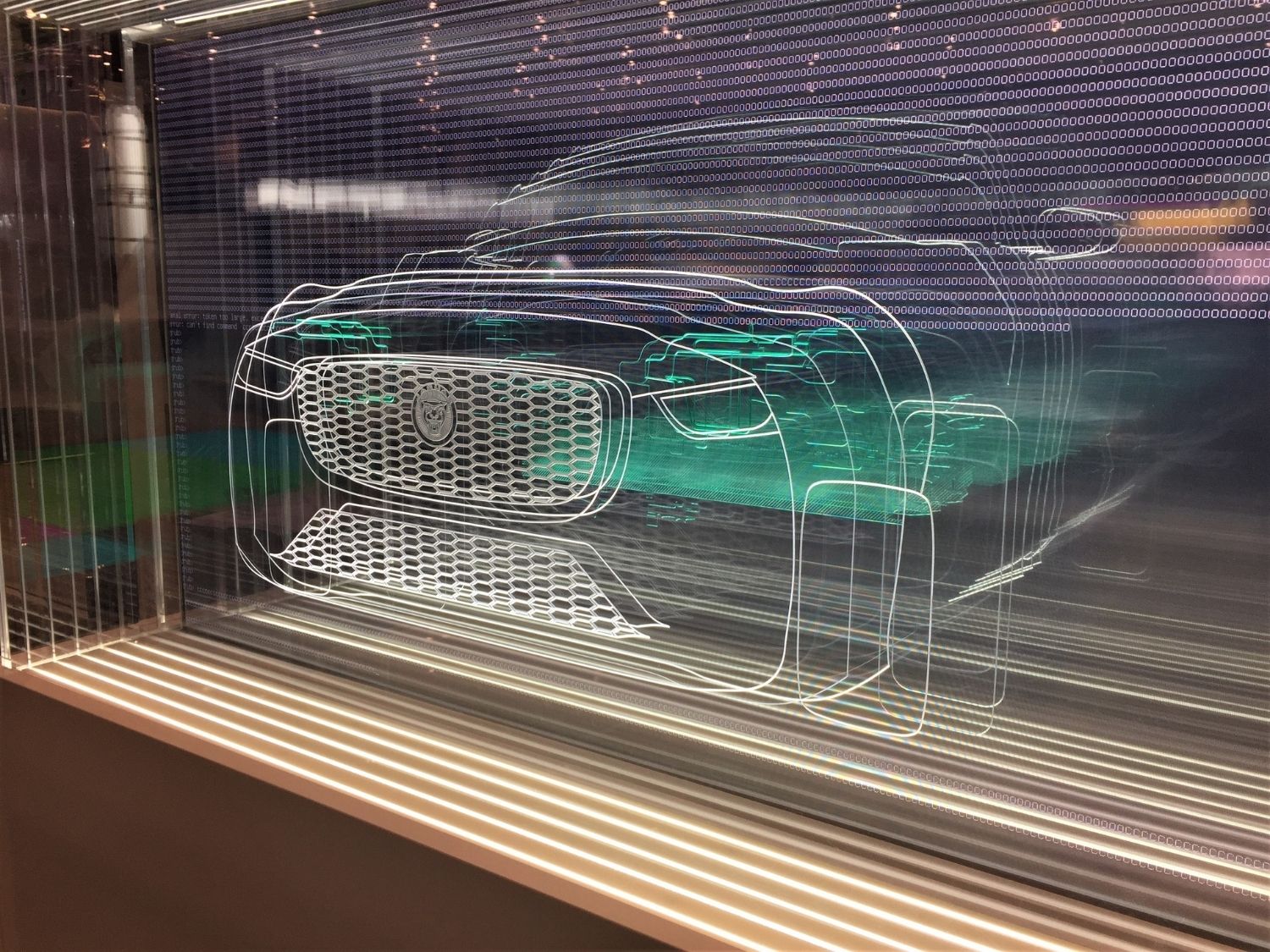 Sheets of clear acrylic with different cross sections of a jaguar engraved into each panel. All the individual panels are lined up to give a picture of the whole car.